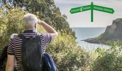 A man looks out to sea from the South West Coast Path.