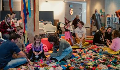 The Mossy Carpet Torre Abbey Aged 4 upwards picture of children sitting on a giant pompom blanket