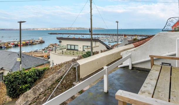 Marina Cottage, Brixham. View from outside seating, across rooftops and top marina and across Tor Bay.