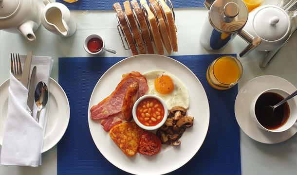 A delicious full English breakfast with a perfectly laid table