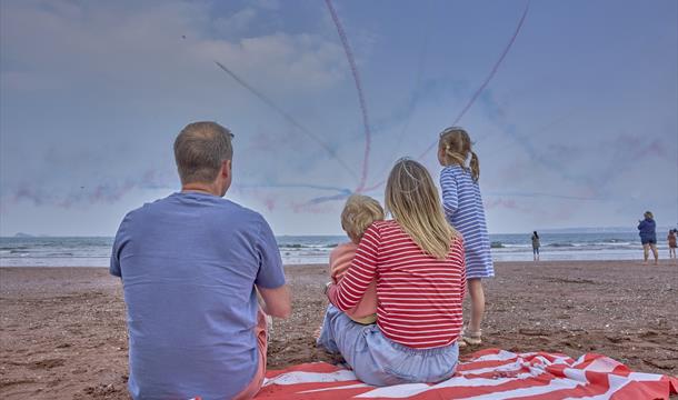 Family watching the Red Arrows at the English Riviera Airshow