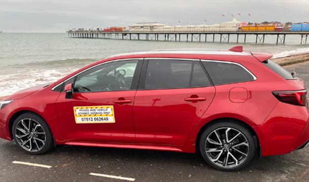 Bayside Private Hire vehicle parked on Paignton Seafront with the pier in the background.