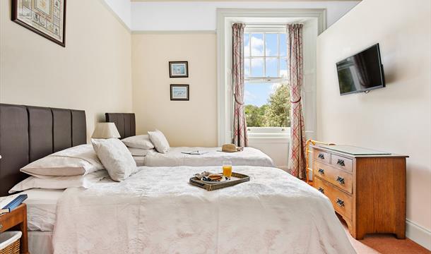 Genova apartment bedroom with twin beds, wall mounted TV and window