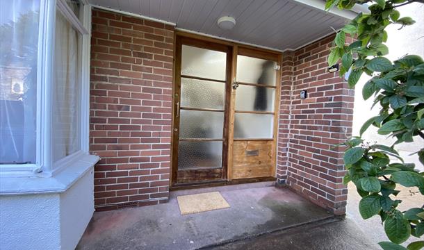 Front door area with security entry light and key safe
