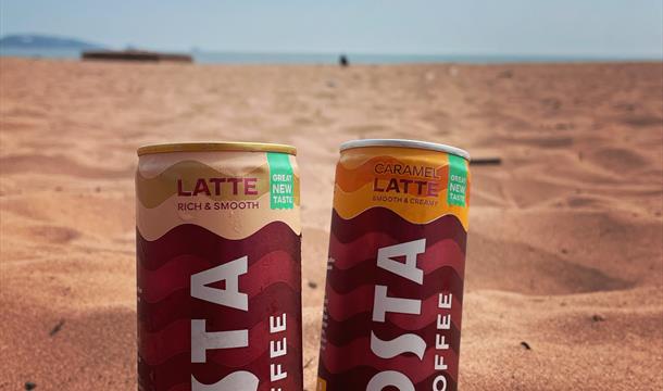 Costa Coffee latte cans on the beach at Goodrington Sands, Devon.