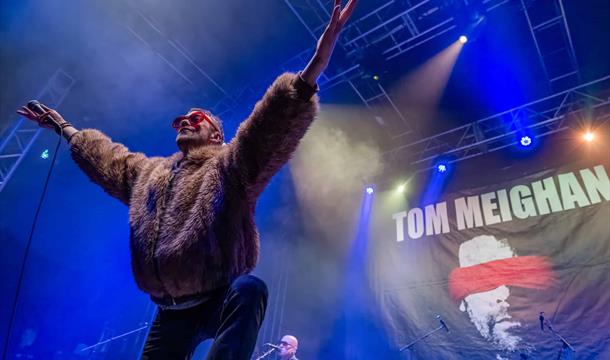 An Evening with Tom Meighan – The Original Voice of Kasabian Palace Theatre Paignton picture of Tom Meighan on stage in a fake fur bomber jacket