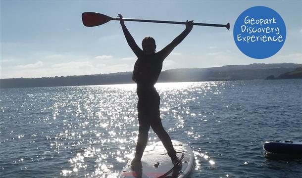 Person standing on a paddleboard, Coastal Paddleboard Adventure, Reach Outdoors