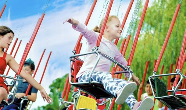 Young girl on a swing ride at Crealy theme park