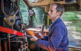 A man working as a steam train driver, Dartmouth Rail and River Boat Company. The Footplate Experience. Paignton to Kingswear.