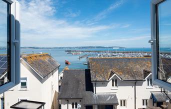Old Ice House, Brixham holiday accommodation. View from open window over rooftops and to the marina and sea.