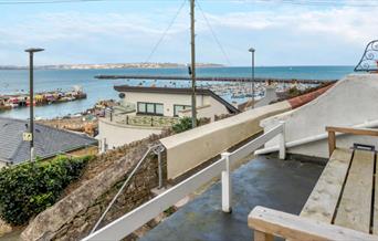 Marina Cottage, Brixham. View from outside seating, across rooftops and top marina and across Tor Bay.