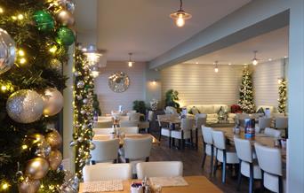 Christmas decorations surrounding tables and chairs ready for dining inside the cafe