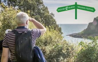 A man looks out to sea from the South West Coast Path.