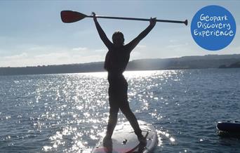 Person standing on a paddleboard, Coastal Paddleboard Adventure, Reach Outdoors