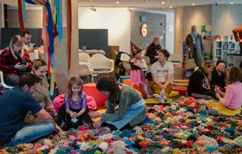 The Mossy Carpet Torre Abbey Aged 4 upwards picture of children sitting on a giant pompom blanket