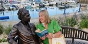 Miss Lemon from English Riviera Custom Tours sitting on Agatha Christie's bench Torquay