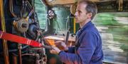 A man working as a steam train driver, Dartmouth Rail and River Boat Company. The Footplate Experience. Paignton to Kingswear.