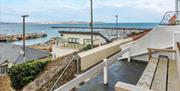 Marina Cottage, Brixham. View from outside seating, across rooftops and top marina and across Tor Bay.