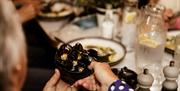 A bowl of shellfish being handed round at a table while dining at the 7 Chefs Torquay event