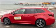 Bayside Private Hire vehicle parked on Paignton Seafront with the pier in the background.