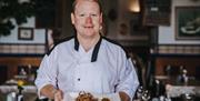 Head Chef carrying a dish of squid at Number 7 Fish Bistro Torquay