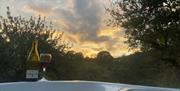 Bottle and glass of wine on the hot tub at Shepherd hut at Hillside Hideaways, Paignton