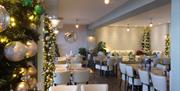 Christmas decorations surrounding tables and chairs ready for dining inside the cafe