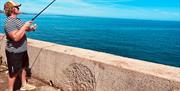 a man fishing off Babbacombe seafront