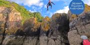 An individual jumping into the sea, Geopark Coasteering Tour, Reach Outdoors