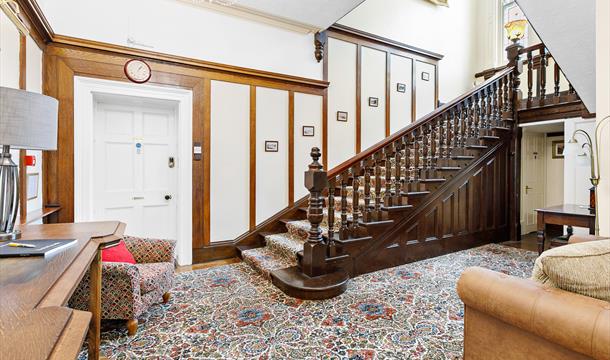 Original mahogany sweeping staircase from downstairs hallway