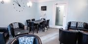 Guest lounge with varied seating areas, large screen tv and table for board-games at Grosvenor House, Torquay, Devon