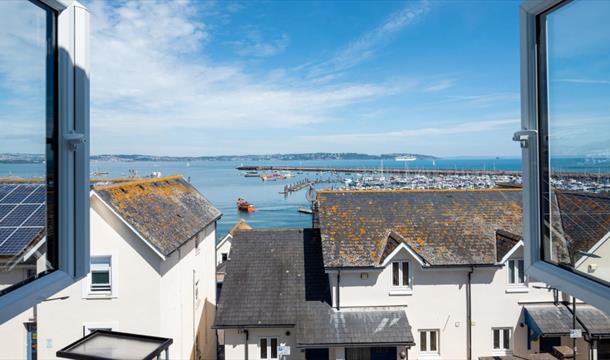 Old Ice House, Brixham holiday accommodation. View from open window over rooftops and to the marina and sea.