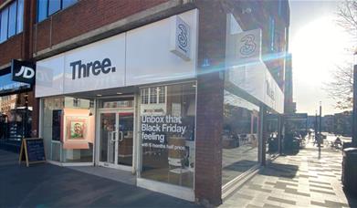 Outside Three in Eltham. A Sleek looking shop with a white design and a black logo.
