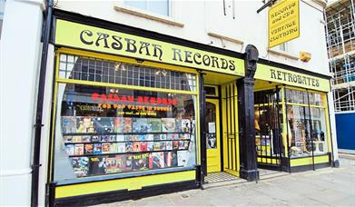 Outside Casbah Records in Greenwich, showing a yellow and black shop with a huge selection of records.