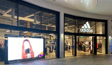 Outside Adidas at The O2. Showing a large and stylish building with a huge selection of items inside.