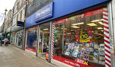 Outside The Works in Woolwich. Showing a blue and white shop front with a range of exciting products inside waiting to be found.