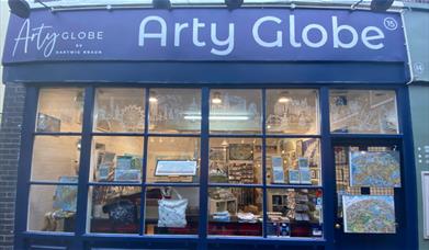 Outside Arty Globe in Greenwich. A blue and white shop front with a stunning artwork display inside the window.