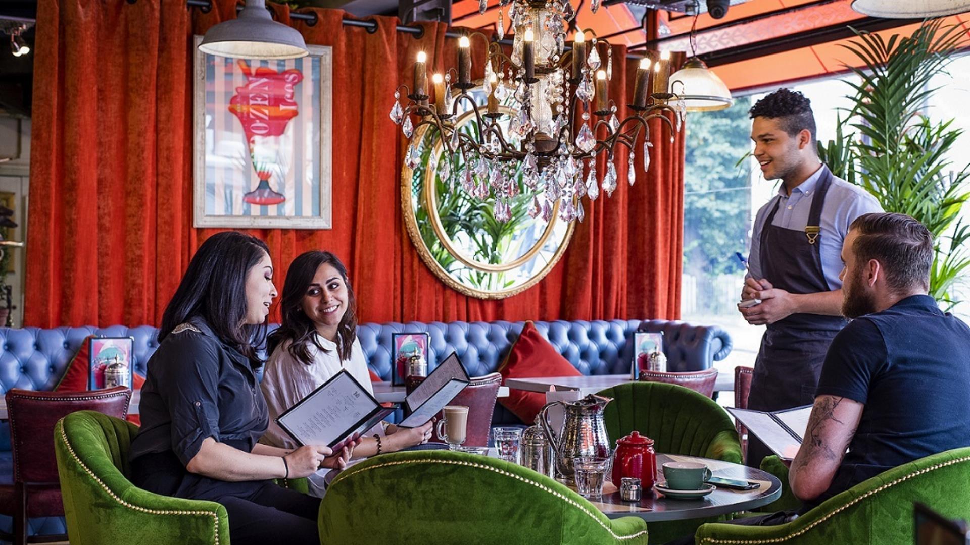 A waiter talks to a group of people at a table in a restaurant in Greenwich.