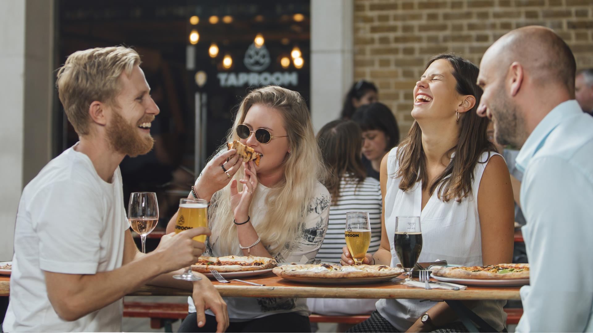 A group eat and drink at The Taproom in Woolwich.