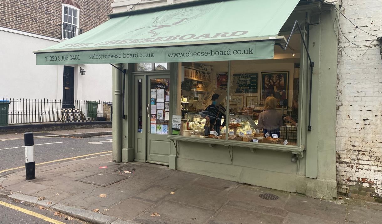 Outside The Cheeseboard in Greenwich. A green shop with a huge selection of mouth-watering food.