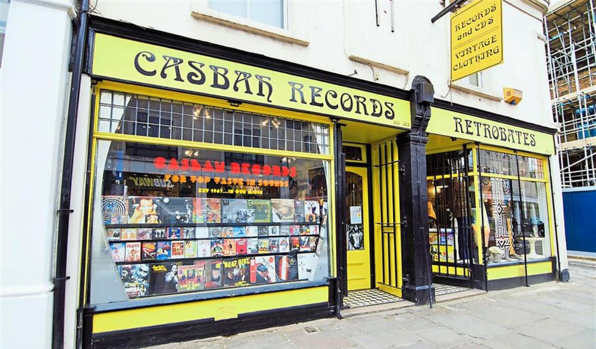 Outside Casbah Records in Greenwich, showing a yellow and black shop with a huge selection of records.