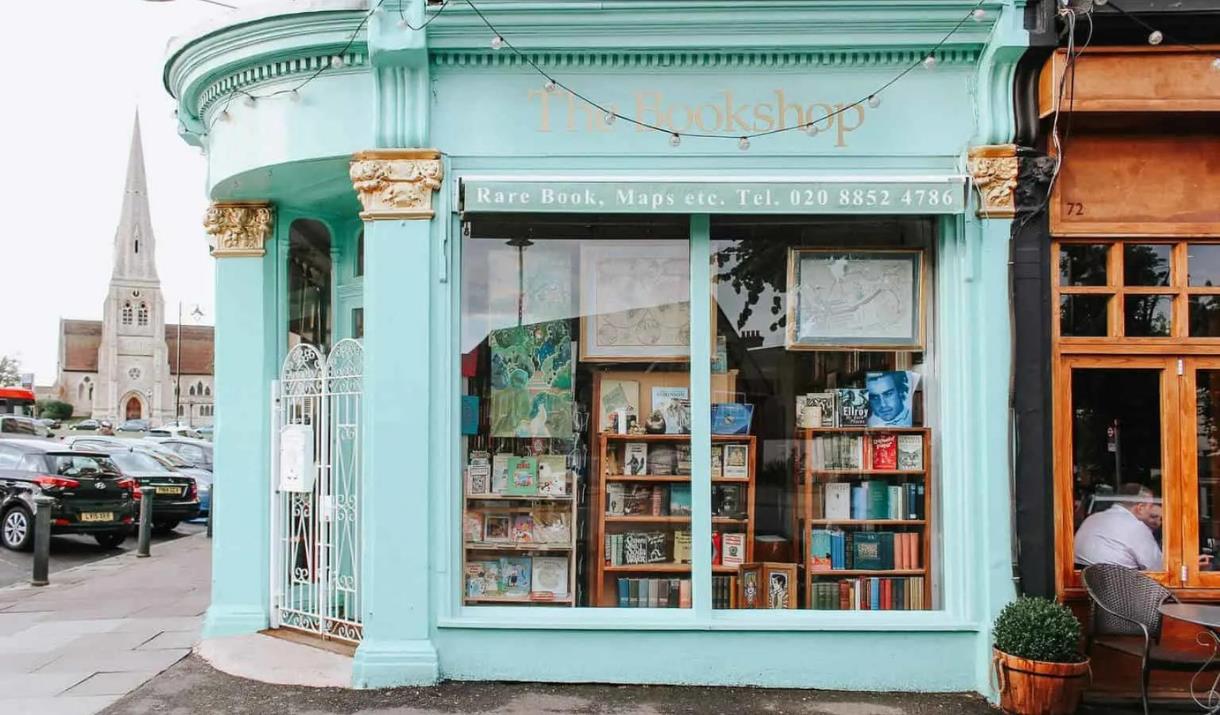 Outside The Bookshop on the Heath in Blackheath. A mint green painted bookshop with a white gate and windows showing a wide range of books.