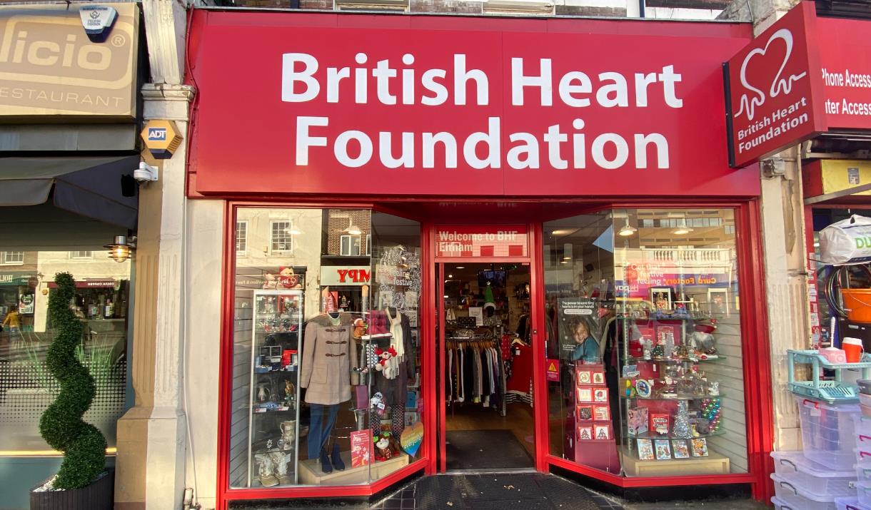 Outside British Heart Foundation in Eltham. The picture shows a red and white shop front with a wide selection of items inside.