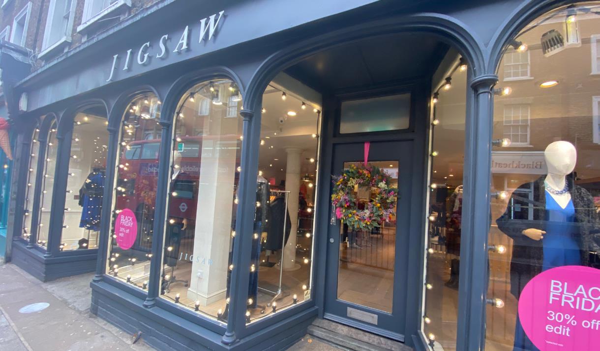 Outside Jigsaw in Blackheath village, a black and white shop with clothes featured through the windows.