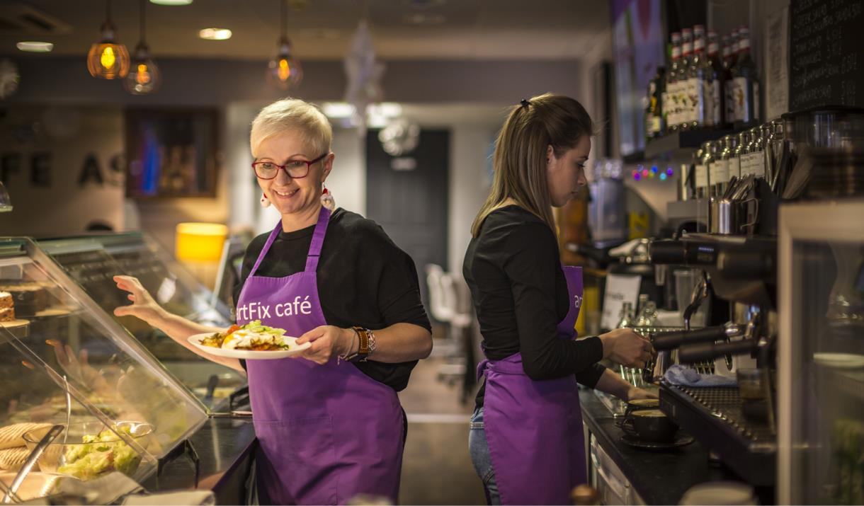 Two ladies working at Artfix cafe serving food and making drinks.