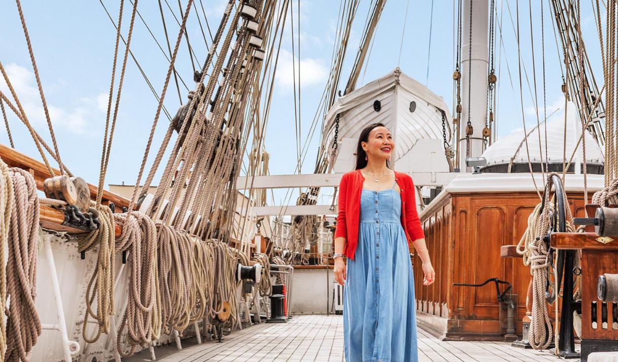 A lady stands on the upper deck of Cutty Sark in Greenwich, London.