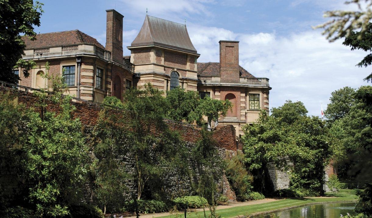 Art Deco mansion Eltham Palace surrounded by its beautiful, lush green gardens and moat.