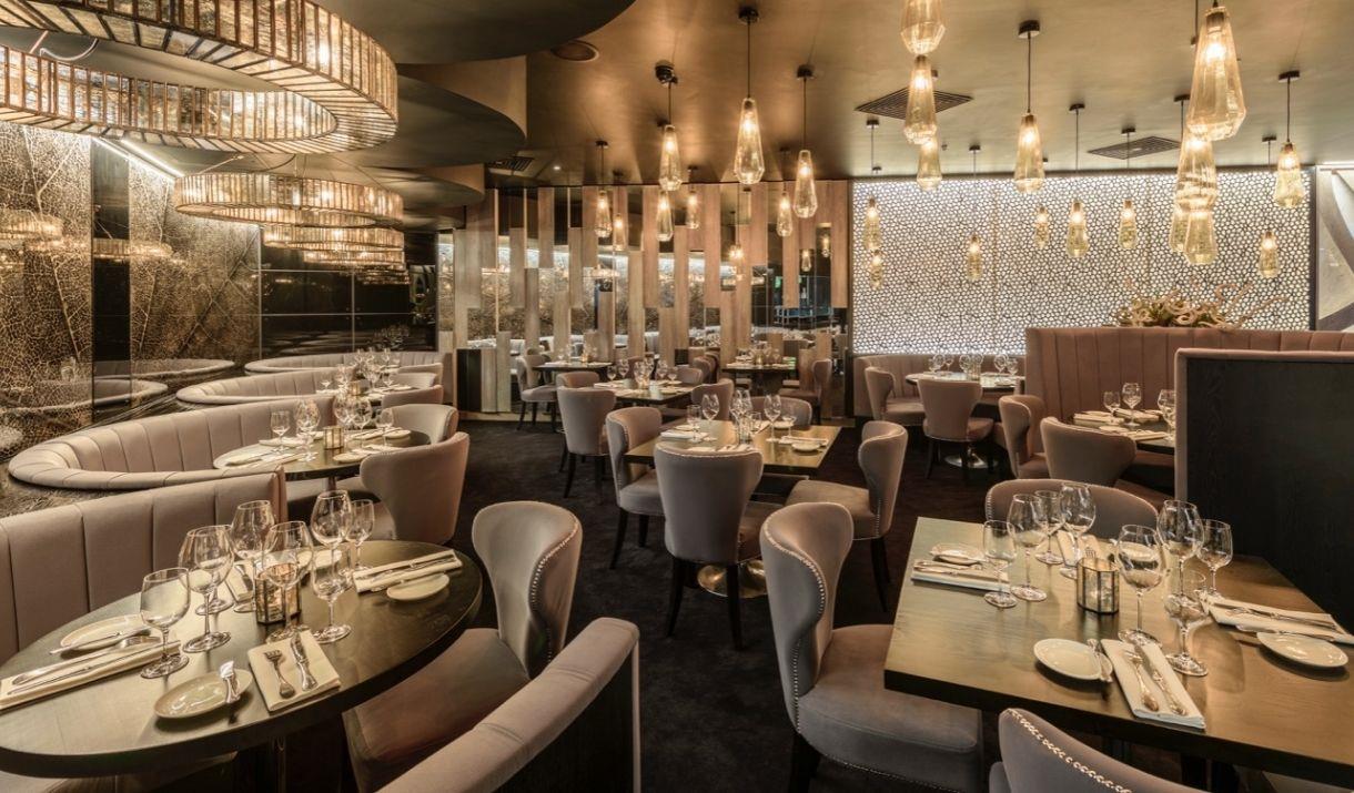 Interior image of Gaucho, The O2 fine dining restaurant with lights set on dim lighting and tables elegantly set.