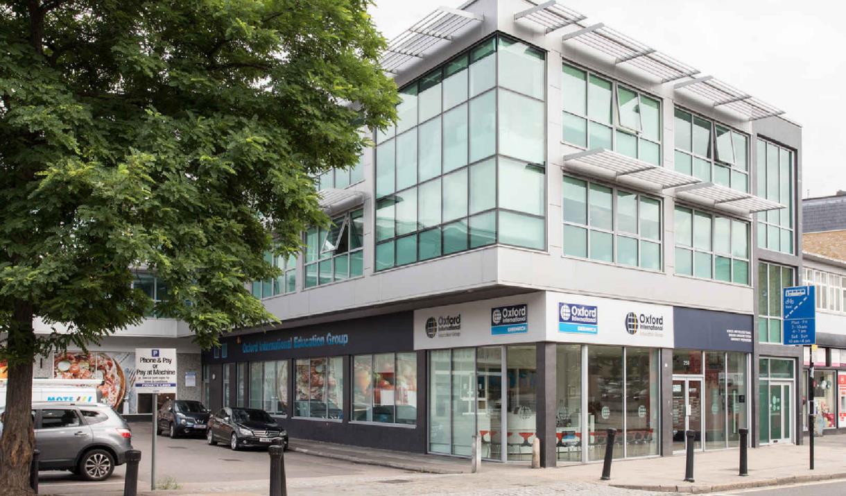 Outside the front of Oxford international education group in Greenwich. showing a square shaped building with lots of windows.