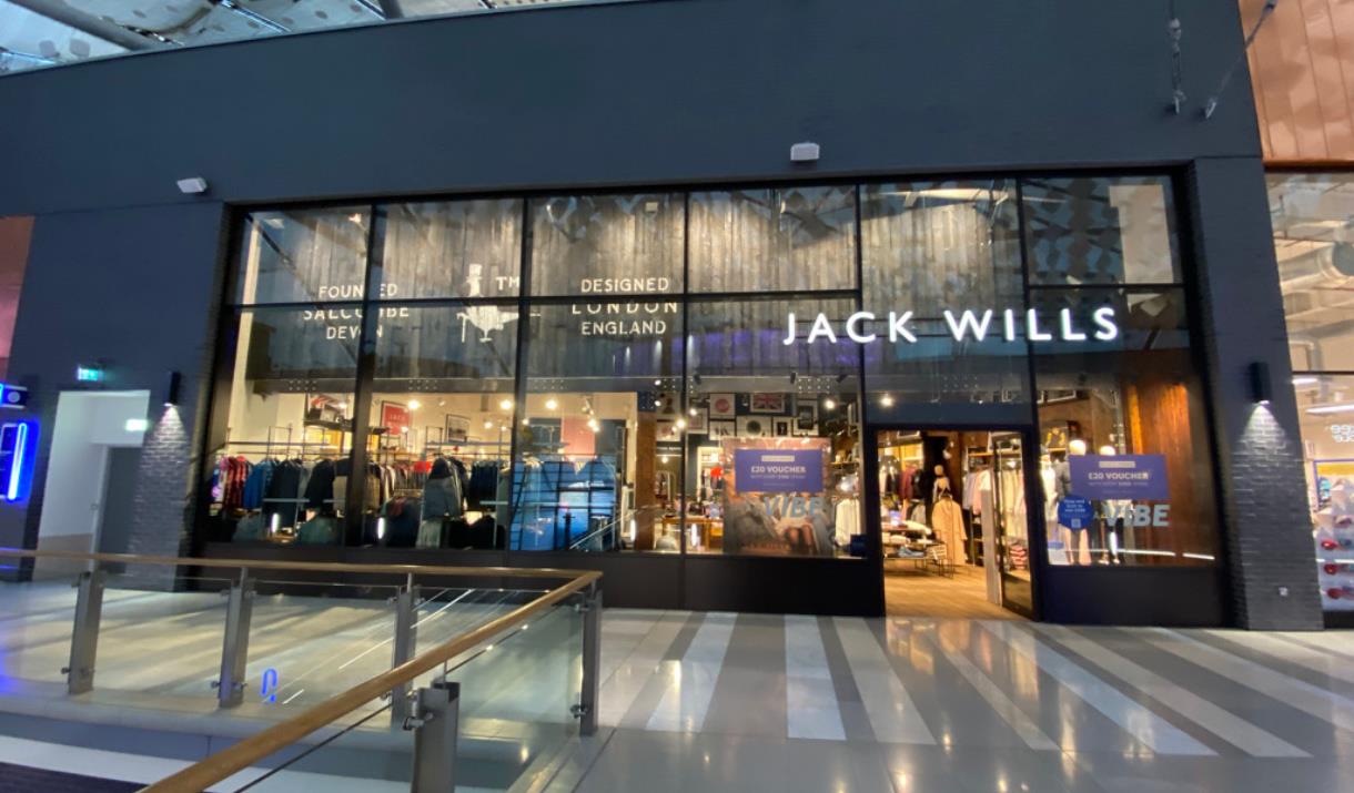Outside Jack Wills at The O2. A stunning and modern building with a white Jack Wills logo at the front. Inside the shop is a huge selection of product